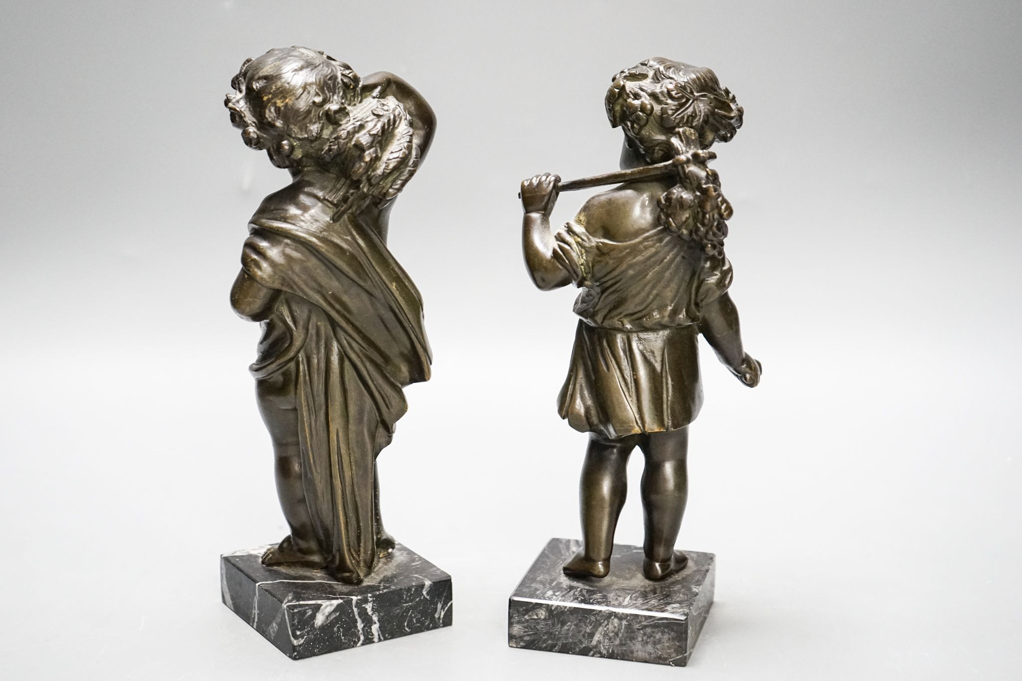 A pair of Victorian bronze putti emblematic of Summer and Autumn, on marble bases 22cm